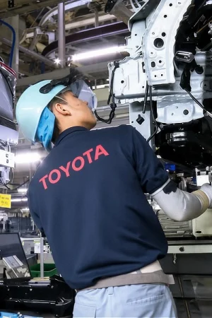 A Toyota factory worker making an inspection on the assembly production line
